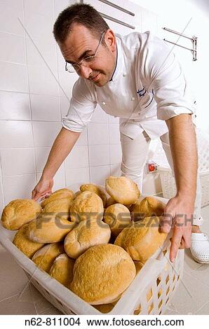 Picture - Baker that collects in a basket on freshly baked bread. Fotosearch