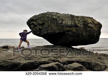 Stock Photo - Balance Rock at low tide, with tourist, Haida Gwaii (Queen Charlotte Islands)- Skidegate, British Columbia, Canada.. Fotosearch