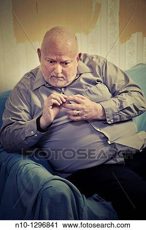 Balding, middle-age man sitting on a sofa View Large Photo Image Stock Image - Balding, middle-age man sitting on a sofa. Fotosearch