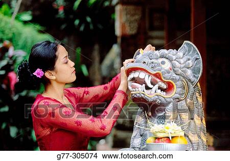 Picture - Balinese woman making offers to gods. Ubud, Indonesia. Fotosearch