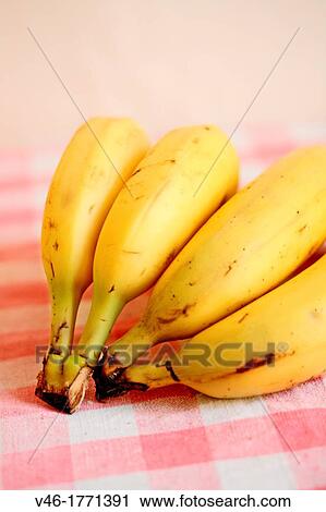 Stock Image - Bananas on red gingham cloth. Fotosearch