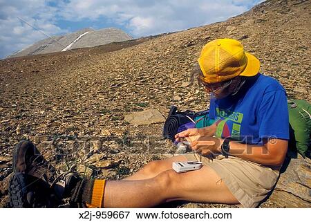 Banff National Park, Alberta Canada - Martha Gruelle, a diabetic, checks her blood sugar level with a glucose meter while resting in Pulsatilla Pass on a backpacking trip in the Canadian Rockies View Large Photo Image Stock Photo - Banff National Park, Alberta Canada - Martha Gruelle, a diabetic, checks her blood sugar level with a glucose meter while resting in Pulsatilla Pass on a backpacking trip in the Canadian Rockies. Fotosearch