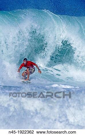 Stock Image - Barbados; Surfer is Riding a Wave; Caribbean Sea.. Fotosearch
