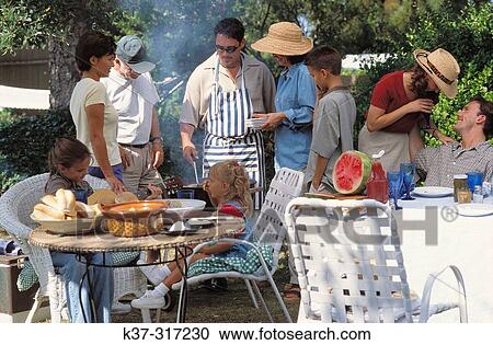 Stock Image - Barbecue with family, friends and neighbors in backyard. Fotosearch