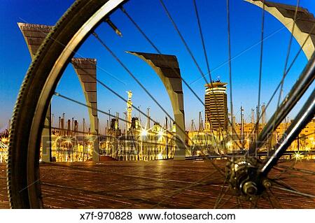 Barcelona: Waterfront across the wheel of bike As seen from Odissea square in Maremagnum shopping mall View Large Photo Image Stock Photo - Barcelona: Waterfront across the wheel of bike As seen from Odissea square in Maremagnum shopping mall. Fotosearch