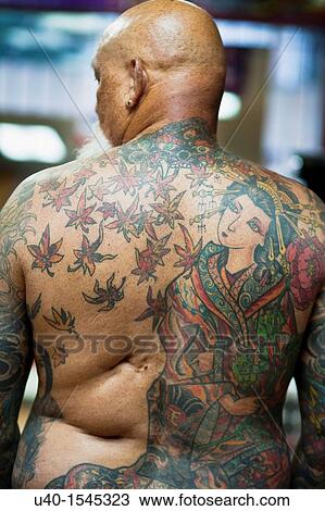 Stock Image - Bare chested man with tattoos, back. Fotosearch