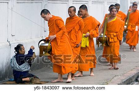 Stock Photo - Barefoot monks collecting food and drink alms early morning Luang Prabang Laos PDR. Fotosearch