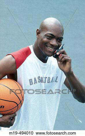 Stock Image - basketball player on a cell phone. Fotosearch