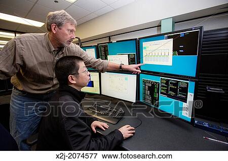 Stock Photo - Batavia, Illinois - Physicists in the control room of the New Muon Lab at the Fermi National Accelerator Laboratory.. Fotosearch