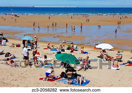 Stock Image - Beach of San Lorenzo with umbrellas, city of Gijon, Asturias, Spain.. Fotosearch