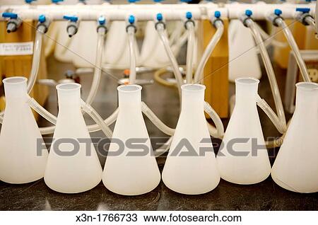 Stock Image - Beakers hooked up to tubes in a laboratory. Fotosearch