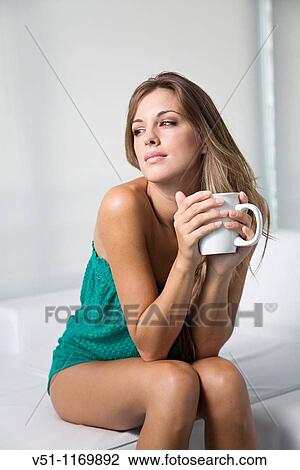 Beatiful pensive blonde woman enjoying a drink at home View Large Photo Image Stock Image - Beatiful pensive blonde woman enjoying a drink at home. Fotosearch