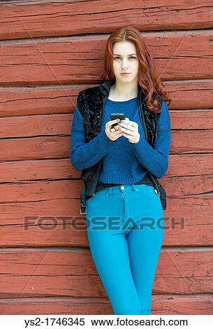 Beatiful young woman with red hair holding a mobile phone View Large Photo Image Stock Photography - Beatiful young woman with red hair holding a mobile phone. Fotosearch
