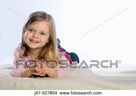 beautiful 3 year old girl with blonde hair, smiling into camera, in the studio, lying on the floor View Large Photo Image Picture - beautiful 3 year old girl with blonde hair, smiling into camera, in the studio, lying on the floor. Fotosearch