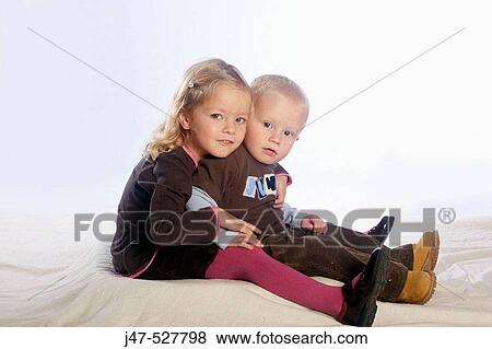 beautiful 3 year old girl with blonde hair, smiling into camera, in the studio, sitting on the floor with her 2, year old brother View Large Photo Image Stock Photo - beautiful 3 year old girl with blonde hair, smiling into camera, in the studio, sitting on the floor with her 2, year old brother. Fotosearch