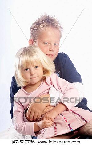 beautiful 3 year old girl with blonde hair sitting on the floor, smiling into camera, in the studio, with her older brother hugging her View Large Photo Image Stock Photograph - beautiful 3 year old girl with blonde hair sitting on the floor, smiling into camera, in the studio, with her older brother hugging her. Fotosearch