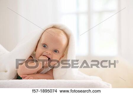Beautiful baby boy lying with a white towel covering his head View Large Photo Image Picture - Beautiful baby boy lying with a white towel covering his head. Fotosearch