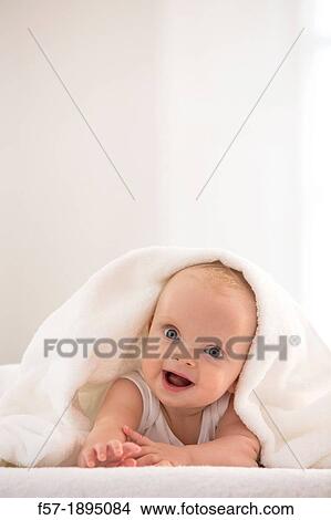 Beautiful baby boy lying with a white towel covering his head View Large Photo Image Picture - Beautiful baby boy lying with a white towel covering his head. Fotosearch