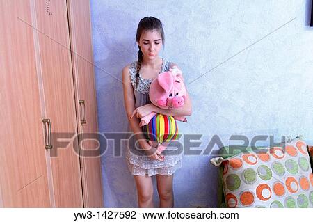 Stock Image - Beautiful Blond girl with her Plush Pig. Fotosearch