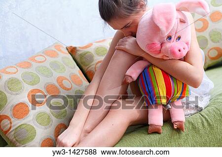 Stock Photo - Beautiful Blond girl with her Plush Pig. Fotosearch