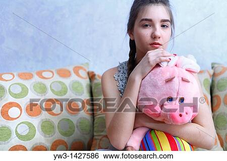 Stock Photograph - Beautiful Blond girl with her Plush Pig. Fotosearch
