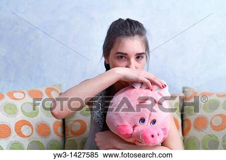 Stock Photography - Beautiful Blond girl with her Plush Pig. Fotosearch
