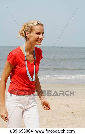 Beautiful blonde woman wearing a red t-shirt and laughing on a beach in India View Large Photo Image Picture - Beautiful blonde woman wearing a red t-shirt and laughing on a beach in India. Fotosearch