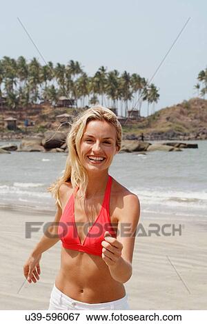 Beautiful blonde woman wearing a red bikini and running towards camera on a beach in India. View Large Photo Image Stock Photo - Beautiful blonde woman wearing a red bikini and running towards camera on a beach in India.. Fotosearch