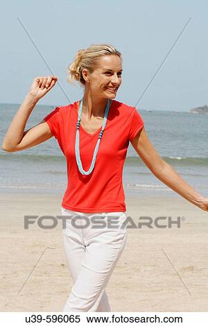 Beautiful blonde woman wearing a red t-shirt and laughing on a beach in India. View Large Photo Image Stock Photography - Beautiful blonde woman wearing a red t-shirt and laughing on a beach in India.. Fotosearch