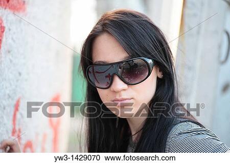 Stock Image - beautiful brunette outdoor portrait against street graffiti. Fotosearch