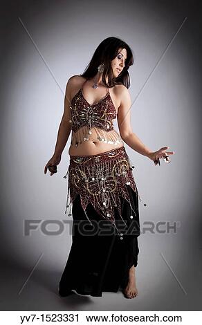 Stock Image - Beautiful brunette practicing belly dancing. Fotosearch