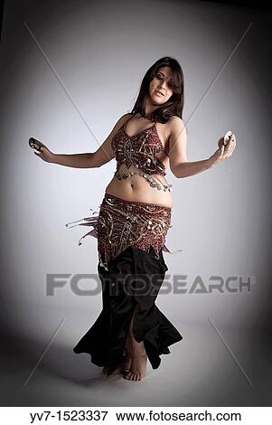Beautiful brunette practicing belly dancing View Large Photo Image Stock Photo - Beautiful brunette practicing belly dancing. Fotosearch