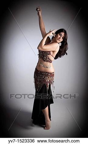 Beautiful brunette practicing belly dancing View Large Photo Image Stock Photograph - Beautiful brunette practicing belly dancing. Fotosearch