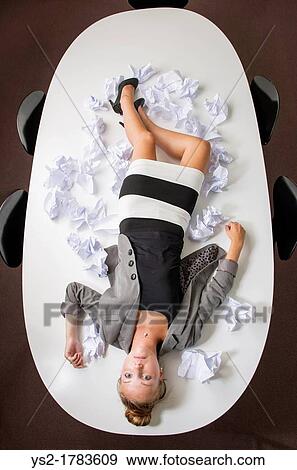 Beautiful businesswoman having a break from too much paperwork She lies exhausted from stress in her workplace View Large Photo Image Stock Photo - Beautiful businesswoman having a break from too much paperwork She lies exhausted from stress in her workplace. Fotosearch