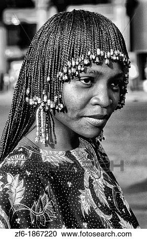 Stock Image - Beautiful Cameroon Africa woman in native costume with head dress and colorful costume in green gown. Fotosearch