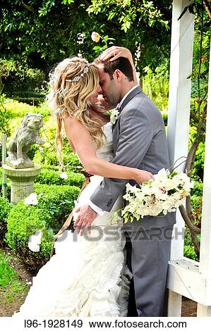 beautiful garden with bride & groom passionately embracing after the wedding View Large Photo Image Stock Photo - beautiful garden with bride & groom passionately embracing after the wedding. Fotosearch