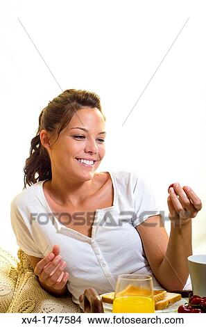 Picture - Beautiful girl take a breakfast on the bed in the morning. Fotosearch