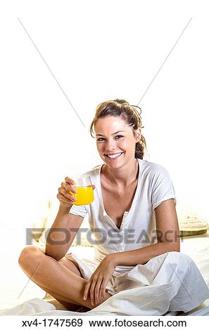 Beautiful girl take a breakfast with orange juice on the bed in the morning View Large Photo Image Stock Photo - Beautiful girl take a breakfast with orange juice on the bed in the morning. Fotosearch