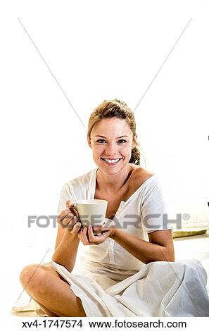 Beautiful girl take a coffee cup breakfast on the bed in the morning View Large Photo Image Picture - Beautiful girl take a coffee cup breakfast on the bed in the morning. Fotosearch