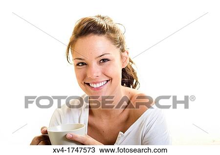 Stock Image - Beautiful girl take a coffee cup breakfast on the bed in the morning. Fotosearch