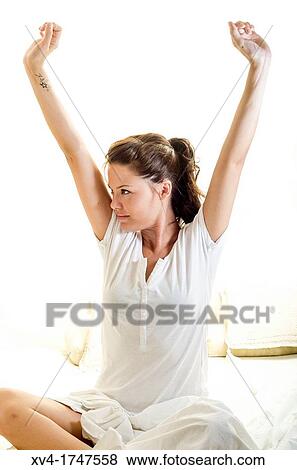 Beautiful girl weak up on bed with arms raised in the morning View Large Photo Image Stock Photo - Beautiful girl weak up on bed with arms raised in the morning. Fotosearch