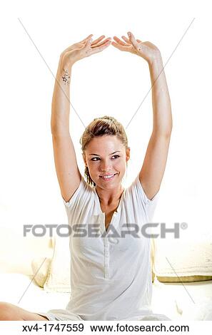 Beautiful girl weak up on bed with arms raised in the morning View Large Photo Image Stock Photo - Beautiful girl weak up on bed with arms raised in the morning. Fotosearch
