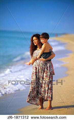 Beautiful pregnant hispanic mother with her young son with love together at beach with waves View Large Photo Image Stock Image - Beautiful pregnant hispanic mother with her young son with love together at beach with waves. Fotosearch