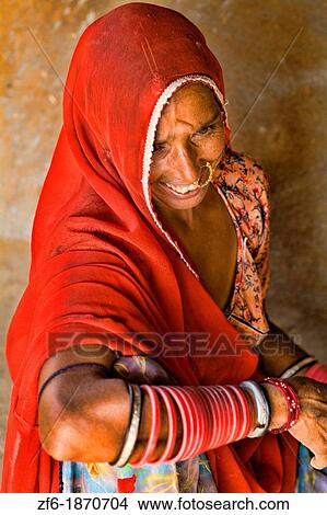 Beautiful red color woman native Hindu portrait from Bishnoi tribe outside of Jodhpur near Great India Thar Desert in Rajasthan India View Large Photo Image Picture - Beautiful red color woman native Hindu portrait from Bishnoi tribe outside of Jodhpur near Great India Thar Desert in Rajasthan India. Fotosearch