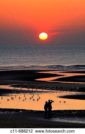 Beautiful sunset over sea and beach with reflections in water and young couple holding hands watching sunset. Blackpool. Lancashire. England. UK View Large Photo Image Stock Image - Beautiful sunset over sea and beach with reflections in water and young couple holding hands watching sunset. Blackpool. Lancashire. England. UK. Fotosearch