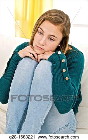Beautiful Teenage girl looking sad and thoughtful sitting on a settee at home View Large Photo Image Stock Image - Beautiful Teenage girl looking sad and thoughtful sitting on a settee at home. Fotosearch