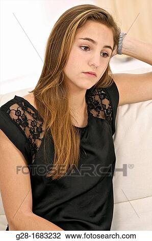 Beautiful Teenage girl looking sad and thoughtful sitting on a settee at home View Large Photo Image Stock Image - Beautiful Teenage girl looking sad and thoughtful sitting on a settee at home. Fotosearch