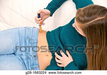 beautiful teenage girl suffering from diabetis and injecting herself insulin in her hip View Large Photo Image Picture - beautiful teenage girl suffering from diabetis and injecting herself insulin in her hip. Fotosearch