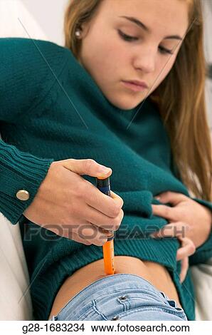 beautiful teenage girl suffering from diabetis and injecting herself insulin in her hip View Large Photo Image Picture - beautiful teenage girl suffering from diabetis and injecting herself insulin in her hip. Fotosearch
