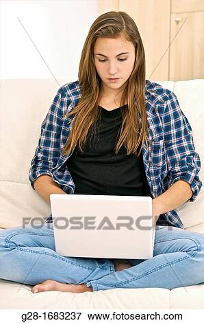 Beautiful teenage girl writing and chatting with her laptop computer View Large Photo Image Stock Photo - Beautiful teenage girl writing and chatting with her laptop computer. Fotosearch